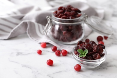 Composition with tasty fresh and dried cranberries on white marble table