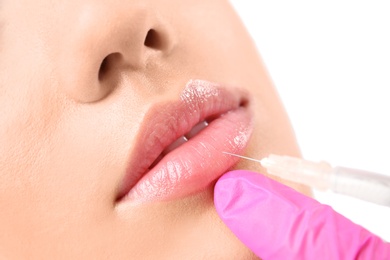 Photo of Young woman getting lip injection in beautician salon, closeup