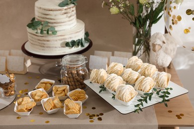 Photo of Beautiful cake and other treats on table in room. Baby shower party