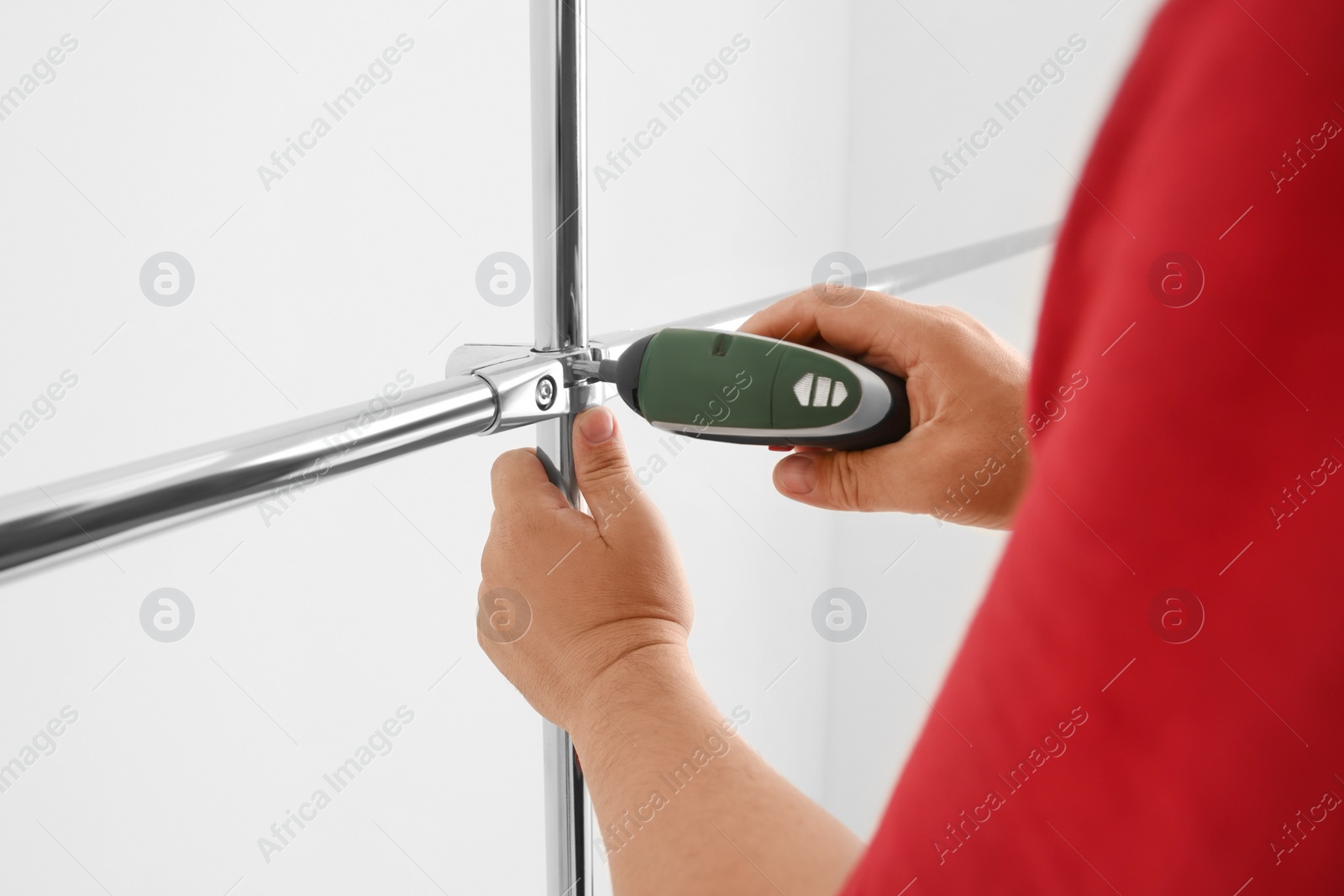 Photo of Worker installing new metal pipes with electric drill, closeup