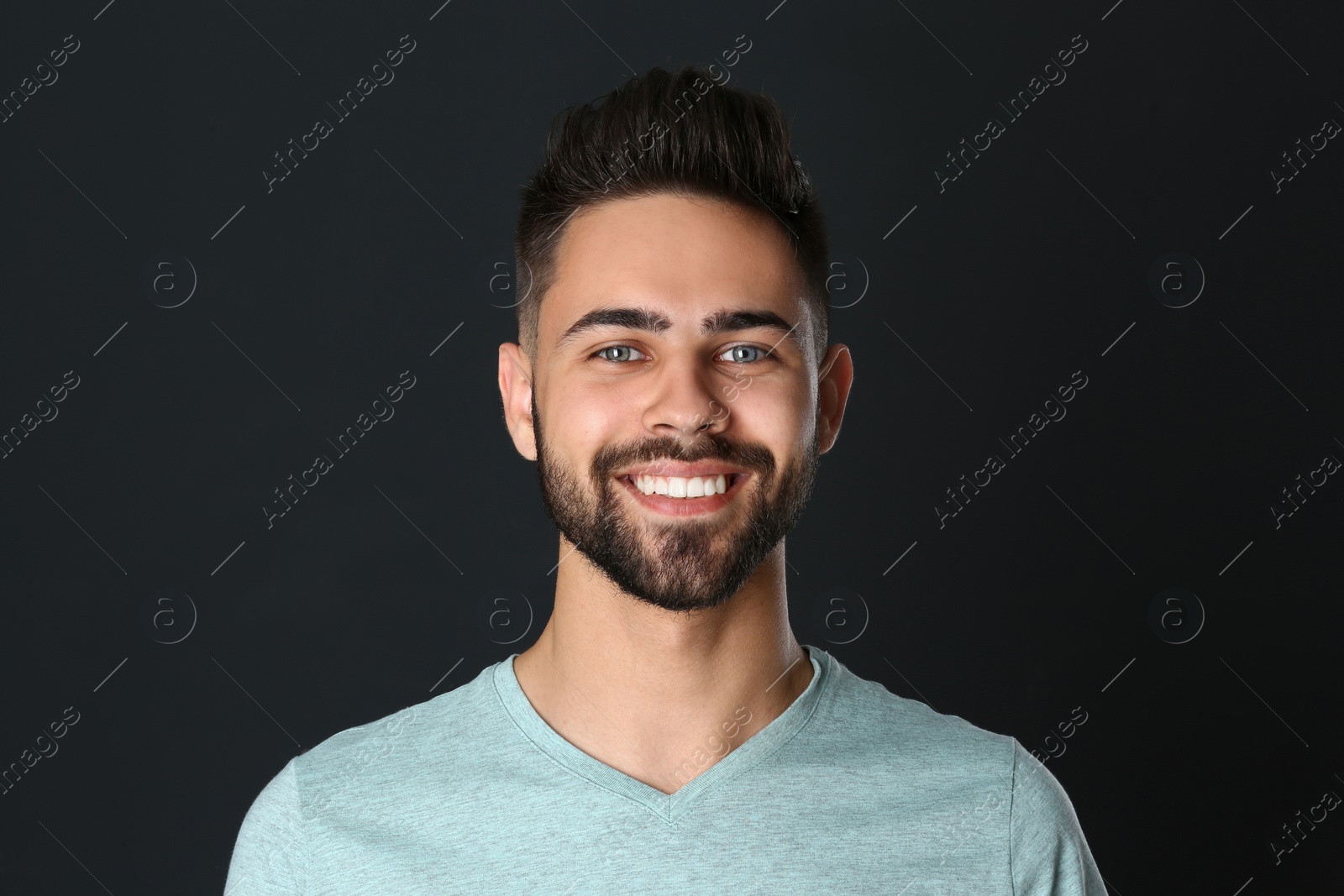 Photo of Portrait of handsome smiling man on black background