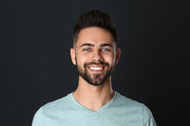 Photo of Portrait of handsome smiling man on black background