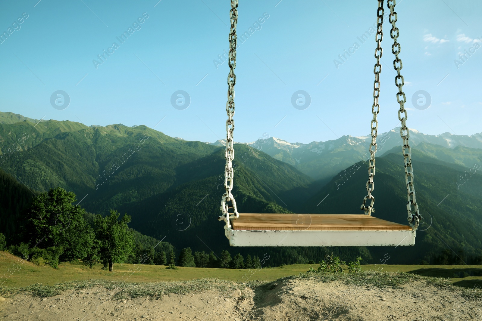 Photo of Outdoor metal swing in beautiful mountains on sunny day, space for text