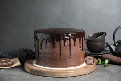 Photo of Freshly made delicious chocolate cake on grey table