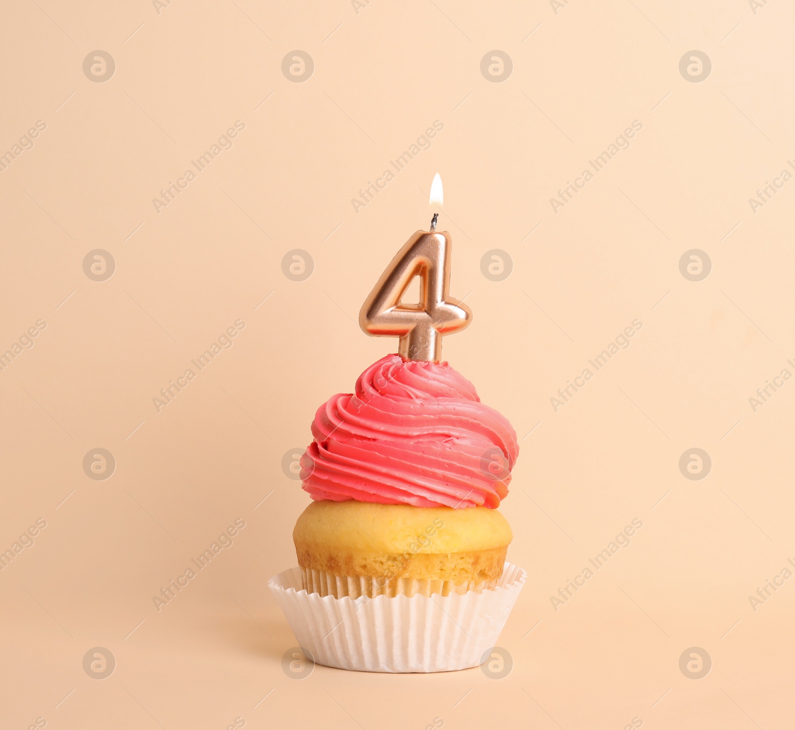 Photo of Birthday cupcake with number four candle on beige background
