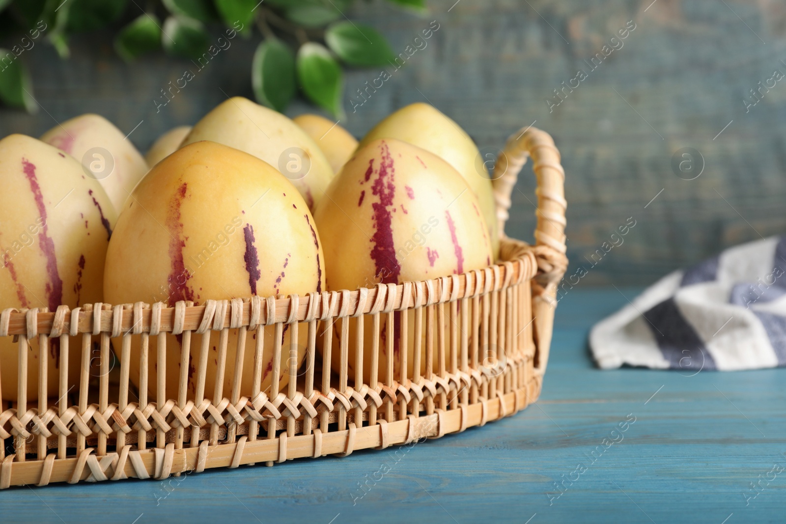 Photo of Fresh ripe pepino melons on light blue wooden table