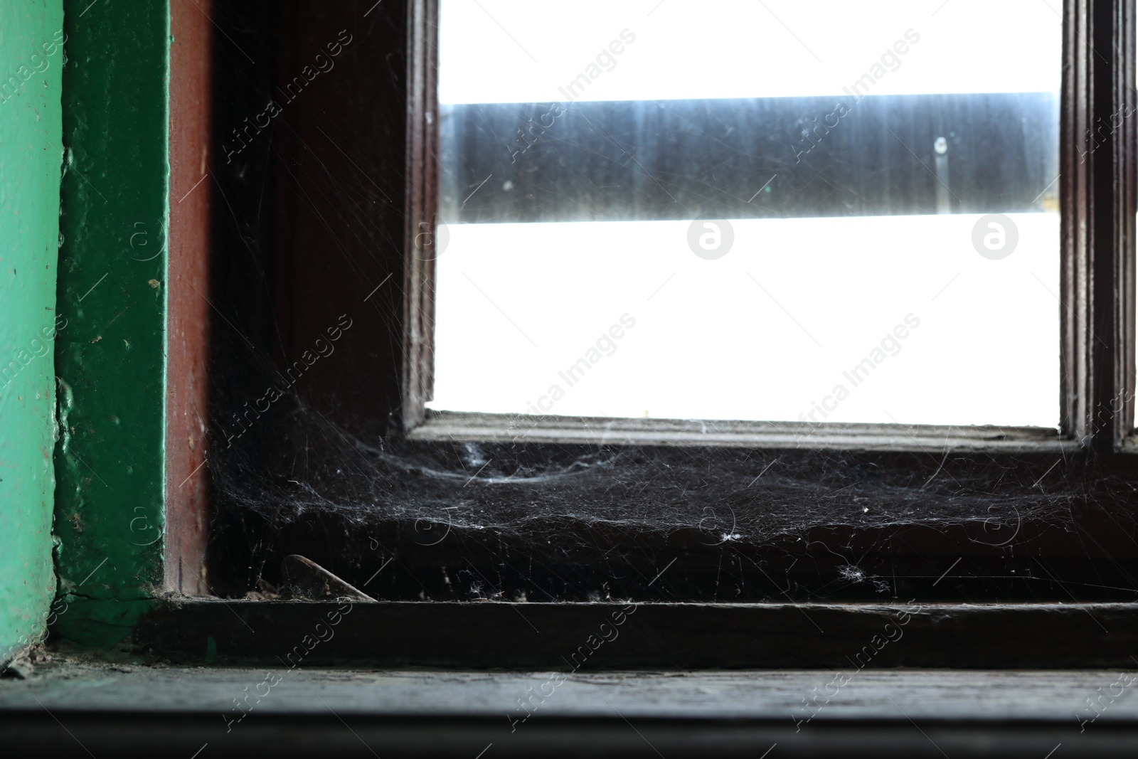 Photo of Cobweb on old wooden window frame indoors, closeup