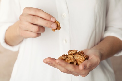 Photo of Woman holding tasty walnuts, closeup. Organic snack