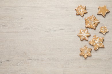 Photo of Tasty Christmas cookies on beige wooden table, flat lay. Space for text
