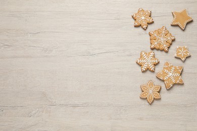 Tasty Christmas cookies on beige wooden table, flat lay. Space for text