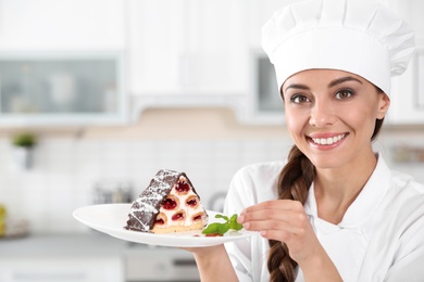 Professional female chef with plate of delicious dessert in kitchen