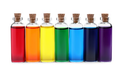 Glass bottles with different food coloring on white background