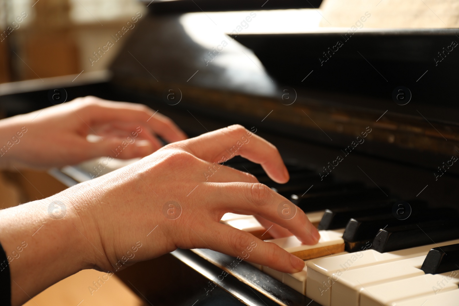 Photo of Young woman playing piano, closeup. Music lesson