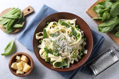 Photo of Delicious pasta with green peas and ingredients on grey table, flat lay