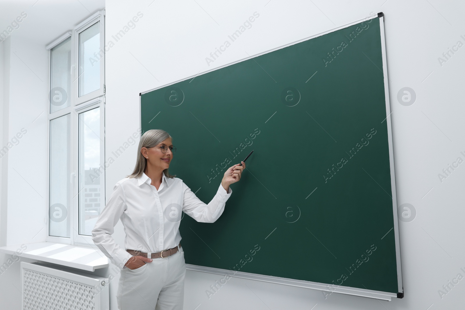 Photo of Professor explaining something at blackboard in classroom, space for text