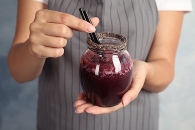 Woman holding jar of delicious acai juice, closeup