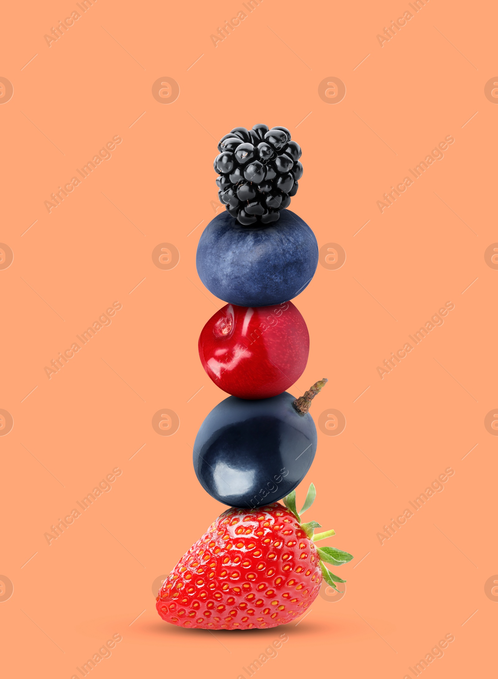 Image of Stack of different fresh tasty berries and cherry on light coral background