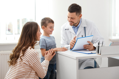 Mother and son visiting pediatrician. Doctor working with patient in hospital