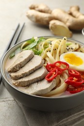 Photo of Delicious ramen in bowl on light table, closeup. Noodle soup