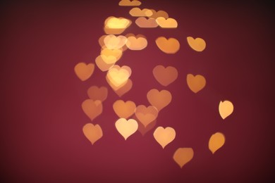 Photo of Blurred view of beautiful lights on burgundy background. Bokeh effect