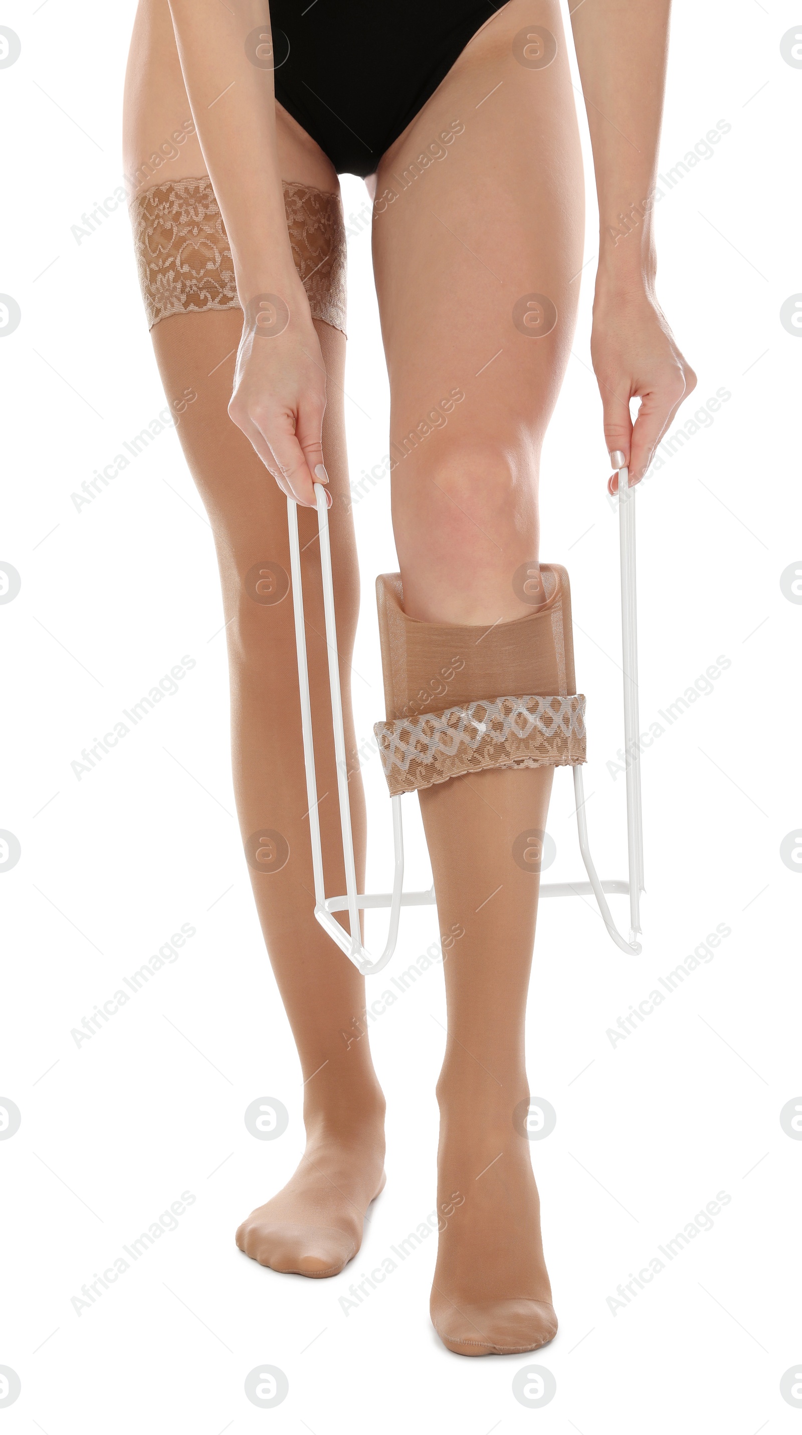 Photo of Woman putting on compression garment with stocking donner against white background, closeup