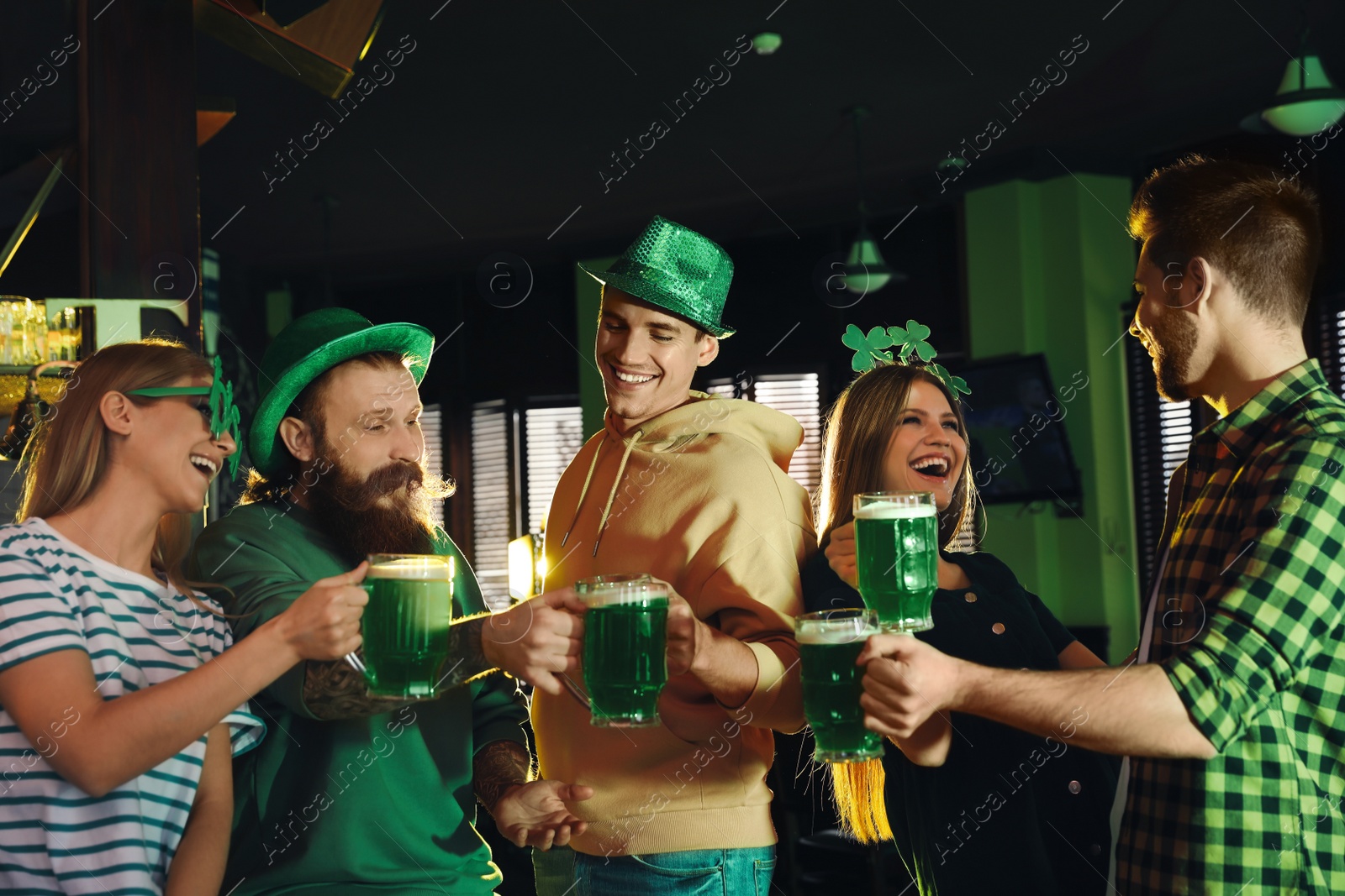 Photo of Group of friends toasting with green beer in pub. St. Patrick's Day celebration