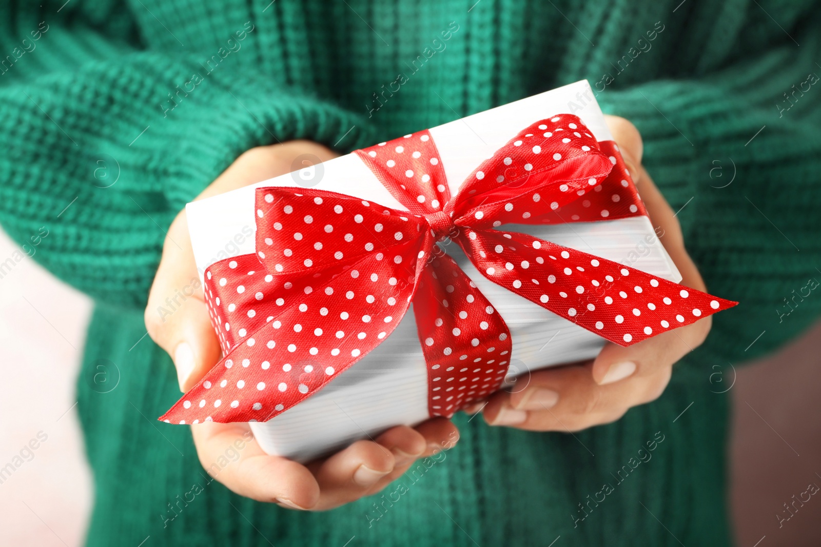 Photo of Woman holding beautiful Christmas gift with bow, closeup