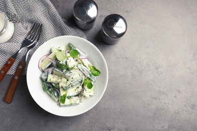 Photo of Flat lay composition with plate of creamy cucumber salad and space for text on table