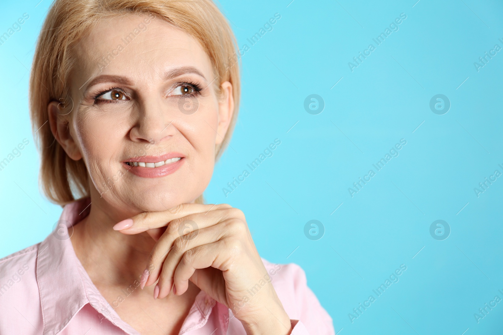 Photo of Portrait of mature woman with beautiful face on blue background. Space for text