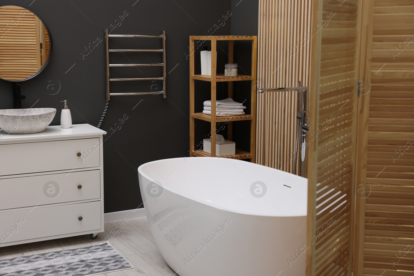 Photo of Stylish bathroom interior with heated towel rail and modern furniture