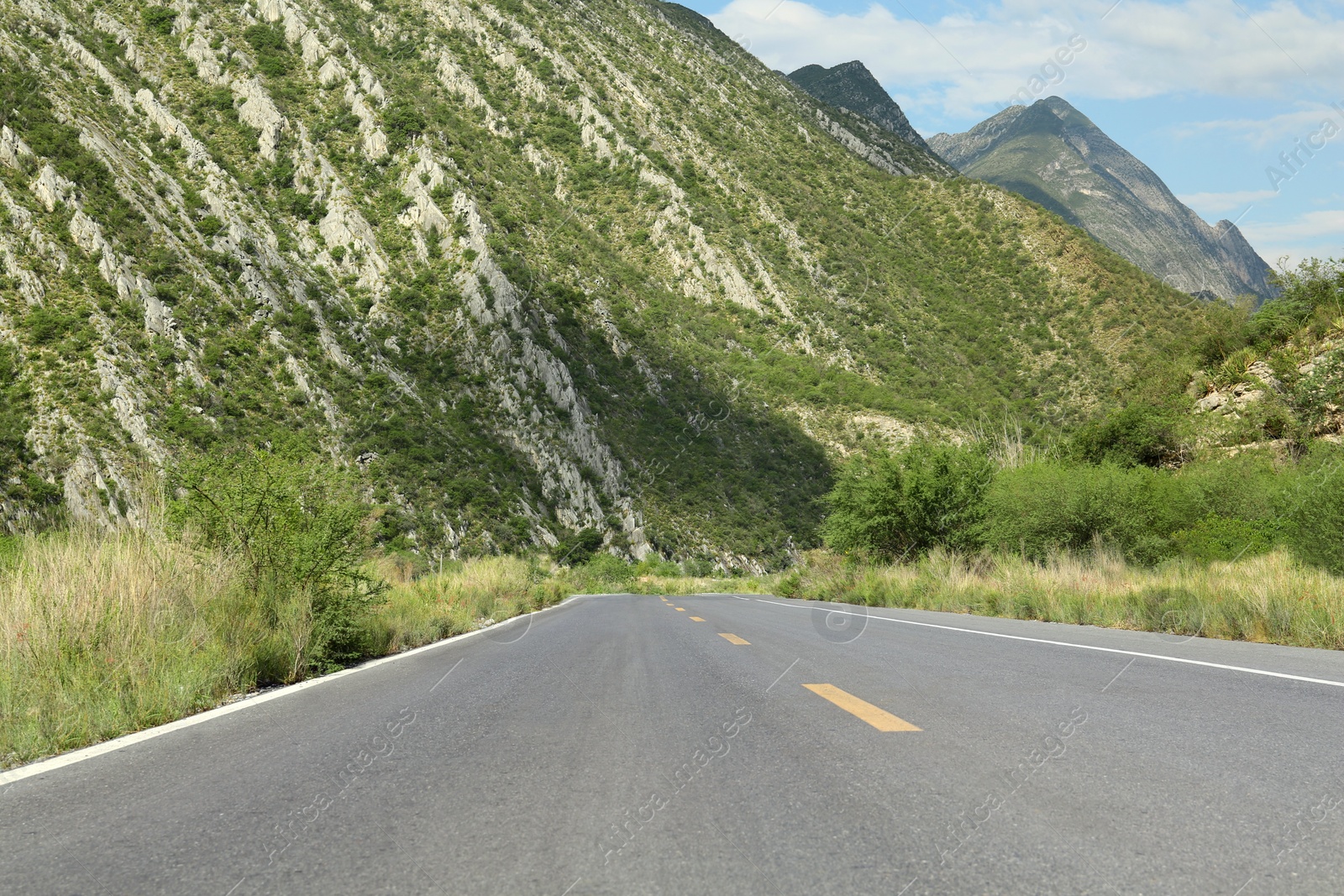 Photo of Beautiful view of empty asphalt highway near mountains outdoors. Road trip