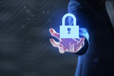 Image of Cyber security concept. Man holding virtual icon of padlock on dark background, closeup