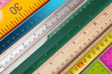Many different rulers on fiberboard, flat lay