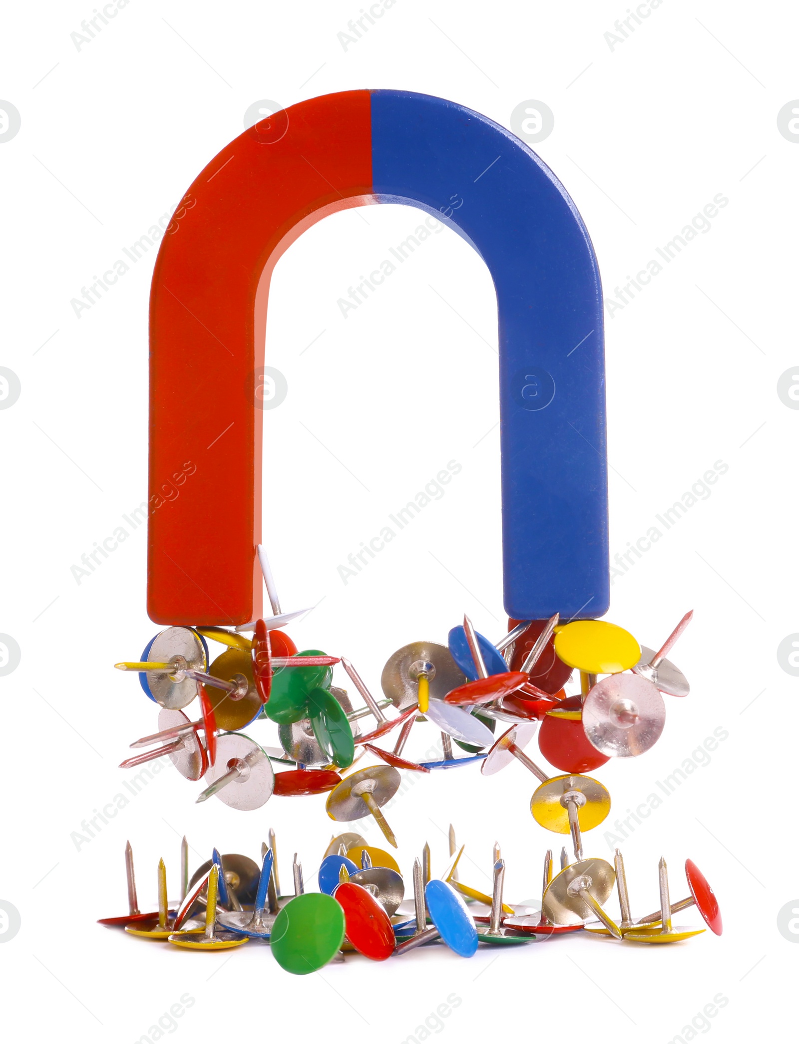 Photo of Horseshoe magnet attracting colorful drawing pins on white background