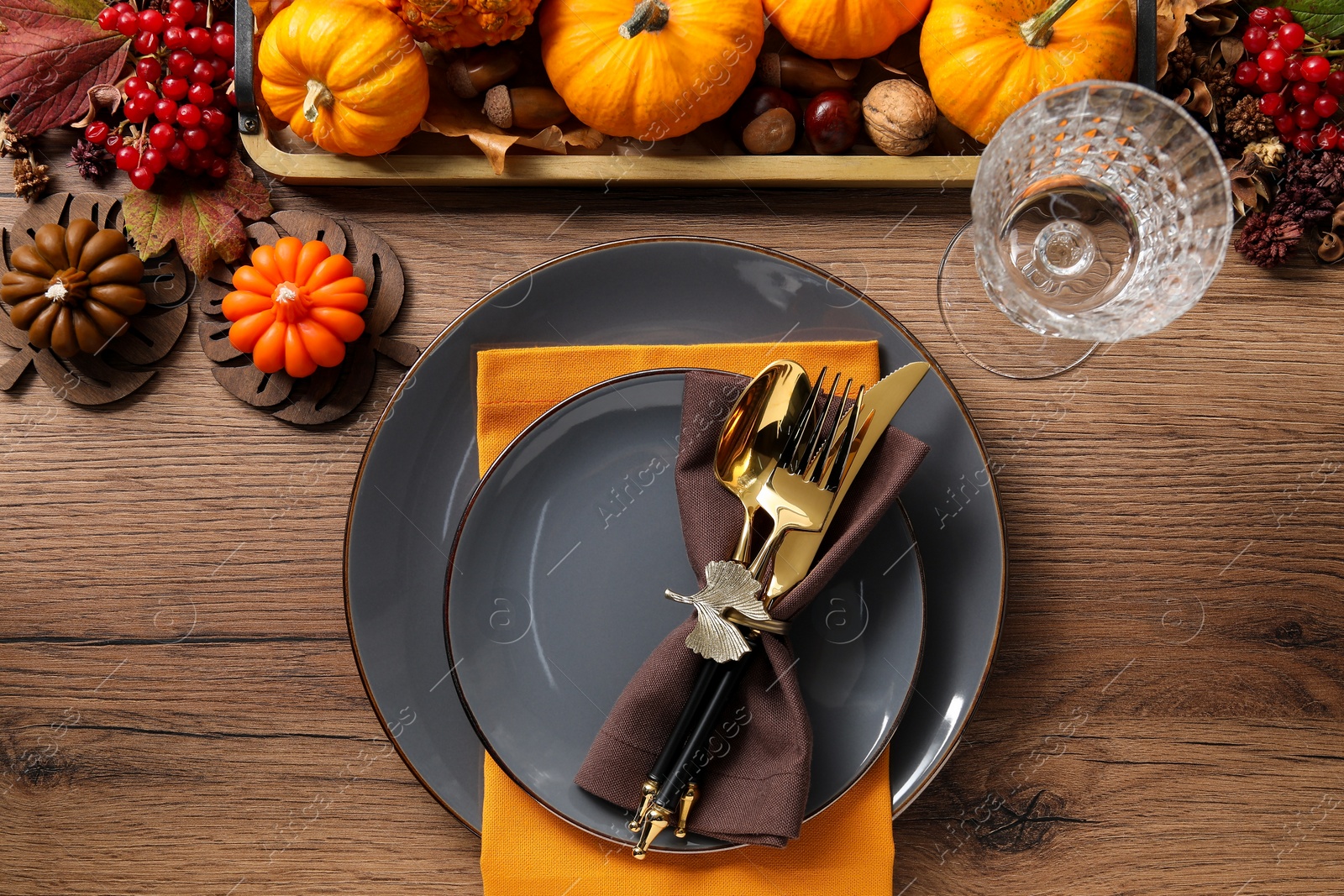 Photo of Thanksgiving table setting. Plates, cutlery, glass and autumn decor, flat lay