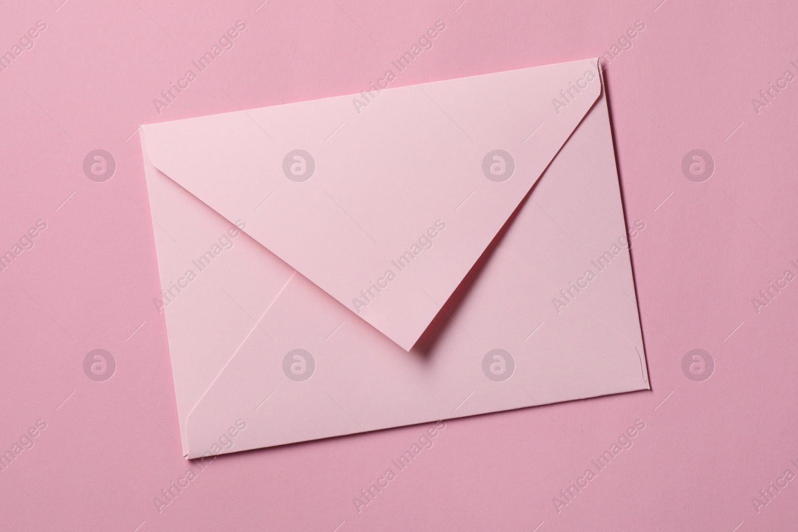 Photo of Letter envelope on pink background, top view