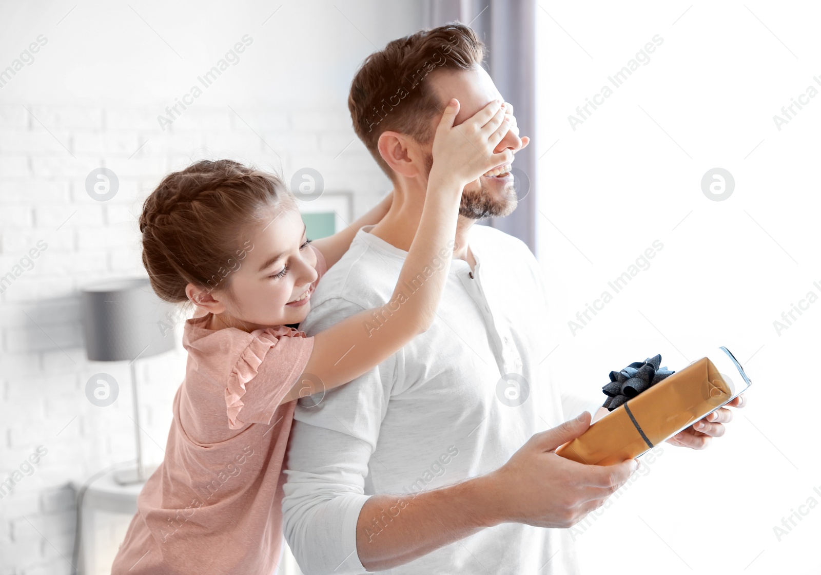 Photo of Man receiving gift for Father's Day from his daughter at home