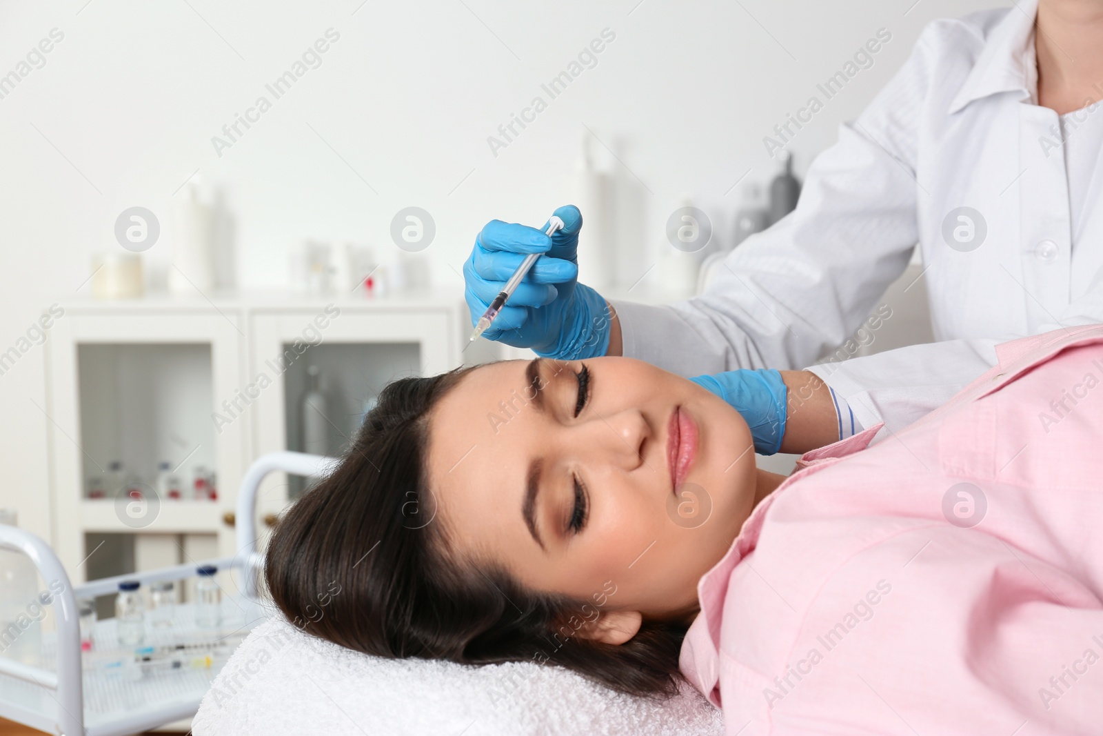 Photo of Young woman with hair loss problem receiving injection in salon