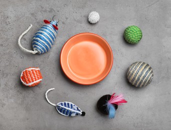 Flat lay composition with different pet toys and feeding bowl on grey background