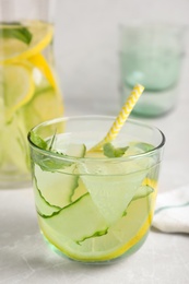 Photo of Refreshing water with cucumber, lemon and mint on white table, closeup