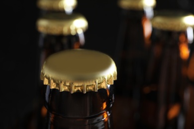 Photo of Many bottles of beer on dark background, closeup view