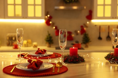 Photo of Christmas table setting with festive decor in kitchen