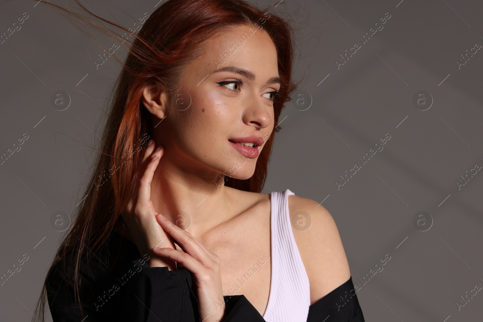 Photo of Beautiful young woman posing on gray background