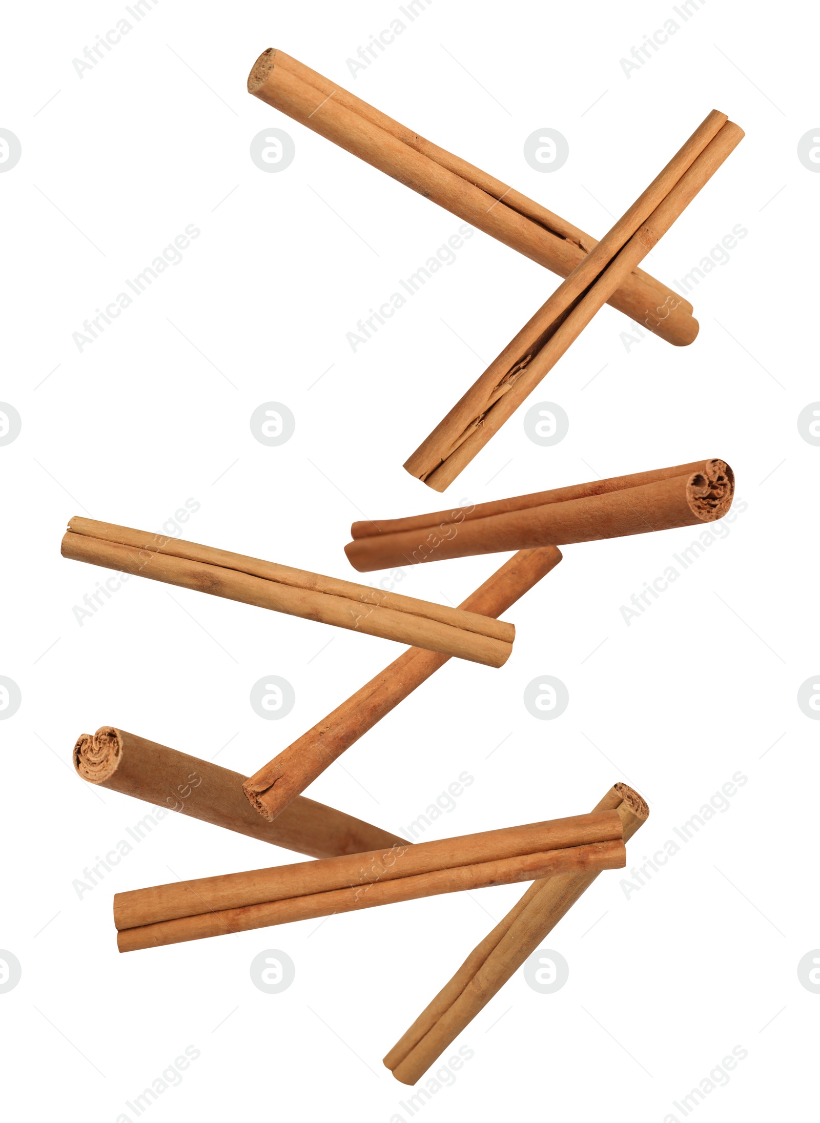 Image of Aromatic cinnamon sticks falling on white background 