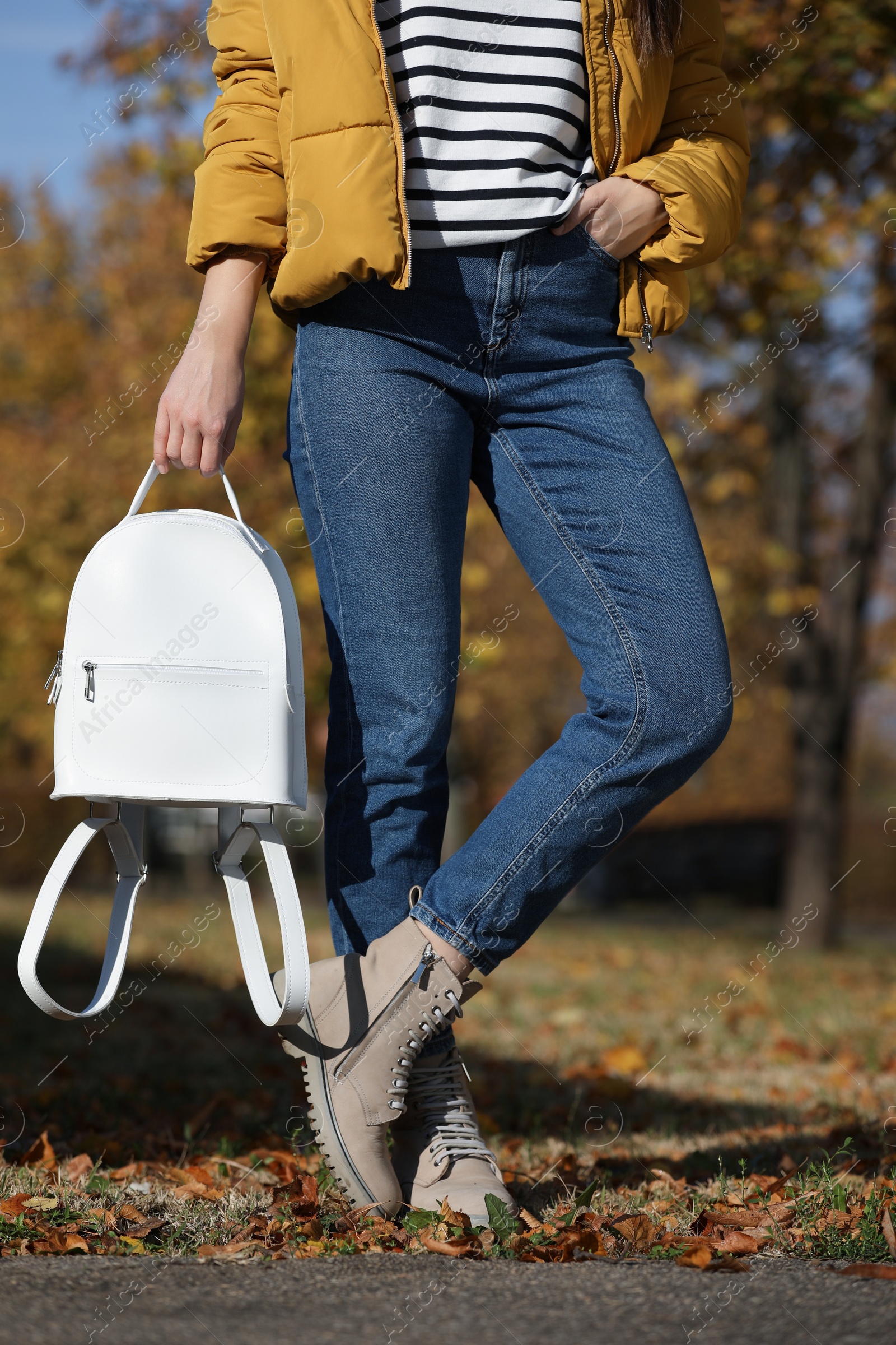 Photo of Young woman with stylish backpack on autumn day, closeup