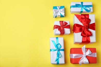 Photo of Flat lay composition with gift boxes on color background