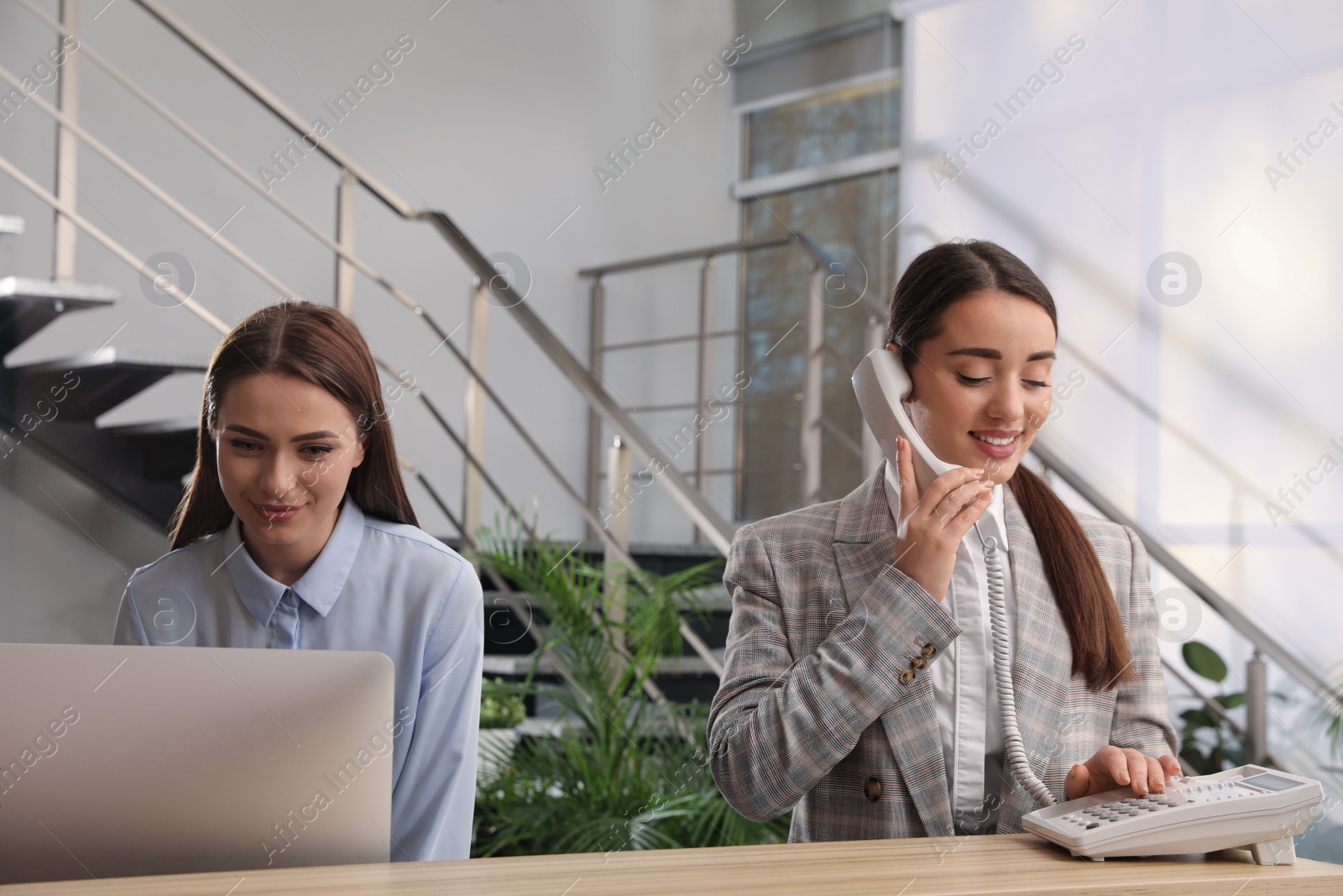 Photo of Female receptionists working at desk in hotel