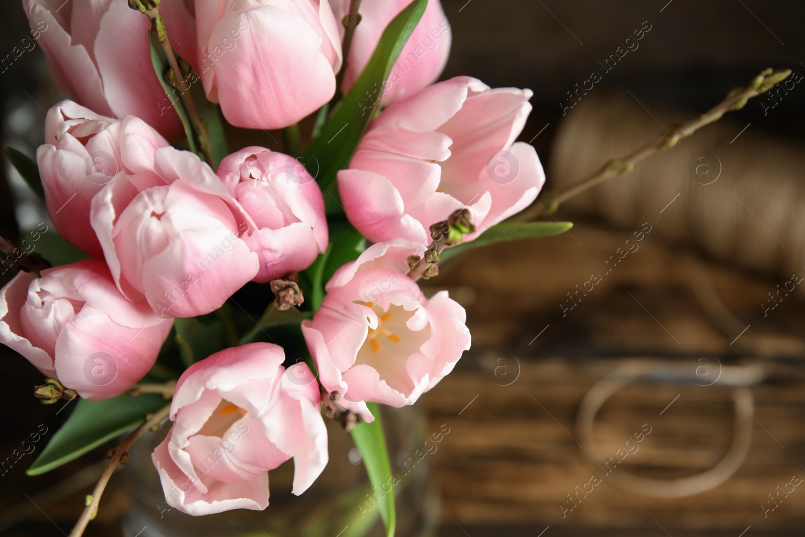 Photo of Beautiful bouquet with spring pink tulips on table, above view