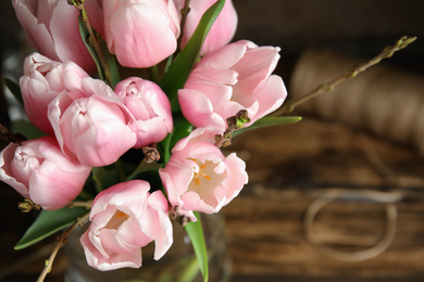 Photo of Beautiful bouquet with spring pink tulips on table, above view