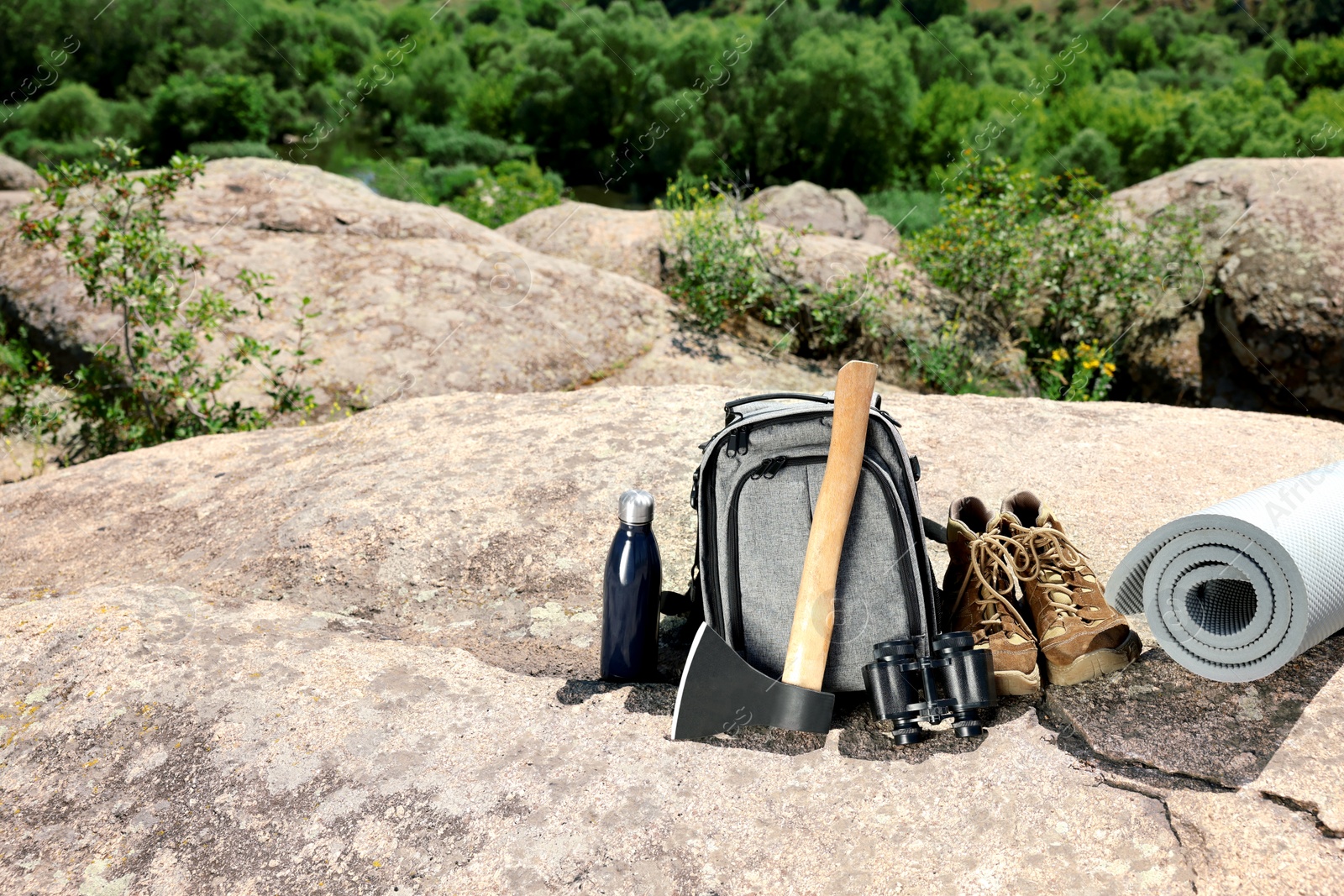 Photo of Set of camping equipment on rock outdoors, space for text